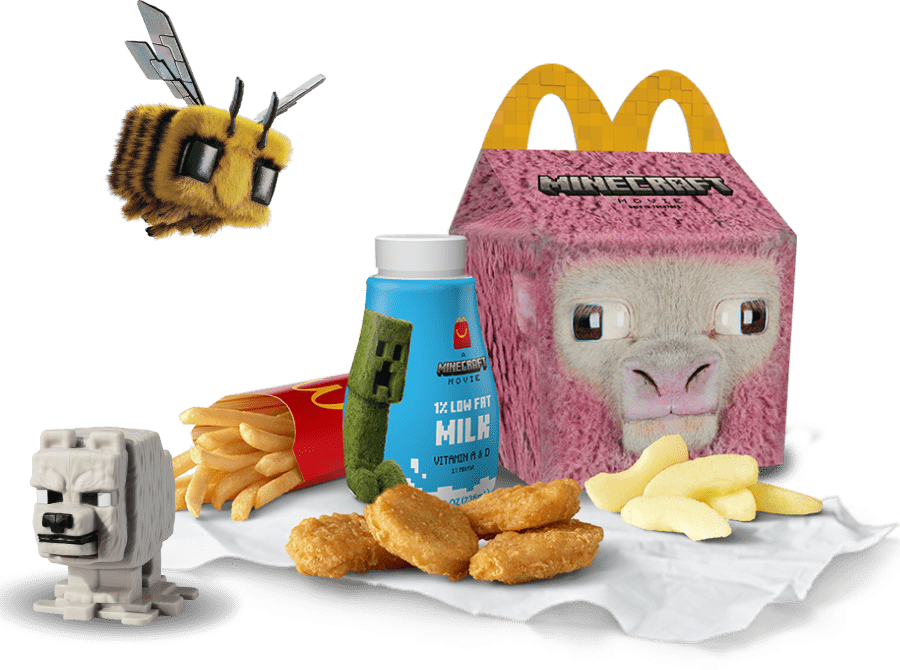 A Minecraft Pink Sheep Happy Meal box with chicken nuggets, fries, apple slices and milk appear in a field of grass. A Minecraft wolf toy sits nearby as a bee is hovering above it.