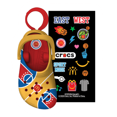 A yellow, red and blue croc that resembles a basketball court and its lines and a colorful sticker pack